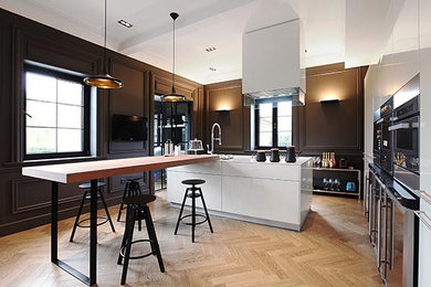 Moderne Küche mit braunem Holzboden und weißem Boden in Sonstige