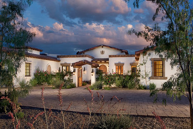 Example of a large tuscan white one-story stucco gable roof design in Phoenix