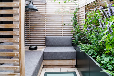 This is an example of a small scandinavian roof xeriscape full sun garden for summer in London with a potted garden, decking and a wood fence.
