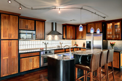 Example of a mid-sized trendy l-shaped dark wood floor open concept kitchen design in Philadelphia with granite countertops, a double-bowl sink, shaker cabinets, medium tone wood cabinets, white backsplash, subway tile backsplash and an island