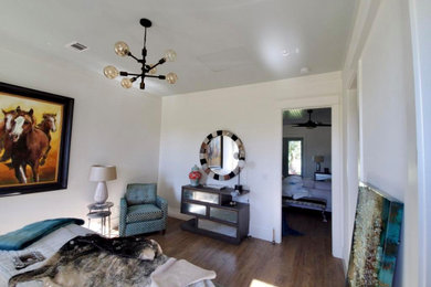 Modelo de habitación de invitados minimalista de tamaño medio con paredes blancas, suelo de madera clara y suelo marrón