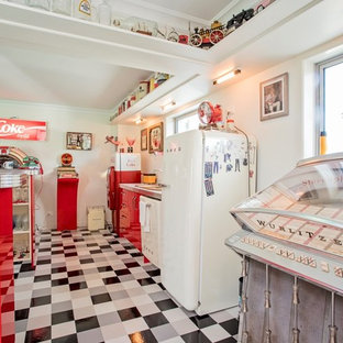 他の地域の巨大なビーチスタイルのおしゃれな着席型バー (赤いキャビネット、リノリウムの床、マルチカラーの床) の写真