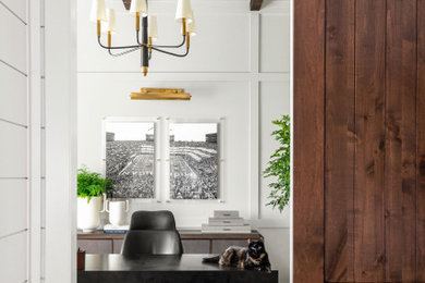 Foto de despacho clásico renovado de tamaño medio con paredes grises, suelo de madera oscura, escritorio independiente, vigas vistas y panelado