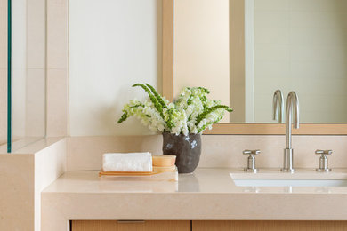 Inspiration for a modern master beige tile and limestone tile bathroom remodel in Los Angeles with light wood cabinets, a drop-in sink, beige countertops and flat-panel cabinets