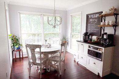 Mid-sized elegant l-shaped medium tone wood floor eat-in kitchen photo in Other with a farmhouse sink, shaker cabinets, white cabinets, marble countertops, white backsplash, subway tile backsplash, stainless steel appliances and an island