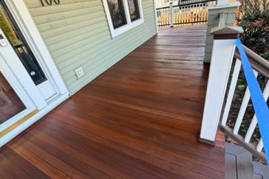 This is an example of a mid-sized traditional wood railing front porch design in New York with a roof extension.