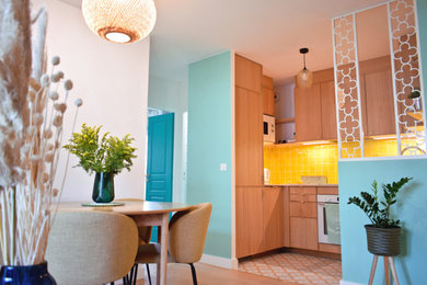 パリにある高級な中くらいなミッドセンチュリースタイルのおしゃれなキッチン (ドロップインシンク、中間色木目調キャビネット、珪岩カウンター、黄色いキッチンパネル、テラコッタタイルのキッチンパネル、白い調理設備、セメントタイルの床、黄色い床、ベージュのキッチンカウンター) の写真