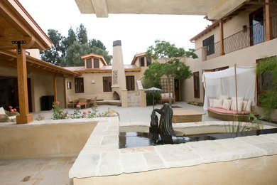 Large tuscan backyard concrete paver patio photo in Orange County with a fire pit and a roof extension
