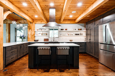 Example of a transitional kitchen design in New York with shaker cabinets, dark wood cabinets and an island