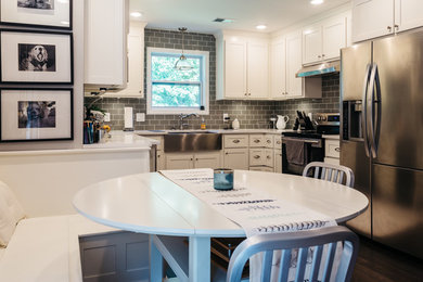 Example of a small arts and crafts u-shaped dark wood floor eat-in kitchen design in Nashville with a farmhouse sink, shaker cabinets, white cabinets, quartz countertops, gray backsplash, glass tile backsplash and stainless steel appliances