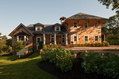 Inspiration for a large timeless brown two-story wood exterior home remodel in Orange County with a shingle roof