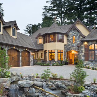 Foto på ett stort vintage beige hus, med två våningar, valmat tak och tak med takplattor