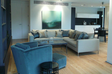 Photo of a large contemporary formal open plan living room in London with grey walls and a wall mounted tv.
