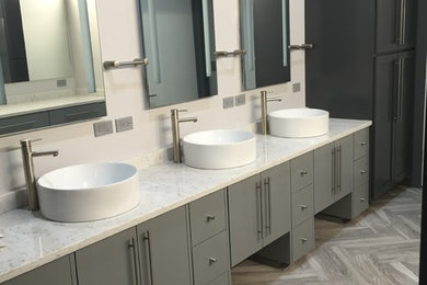 Inspiration for a large transitional master medium tone wood floor and gray floor bathroom remodel in Orange County with flat-panel cabinets, gray cabinets, white walls, a vessel sink, marble countertops and white countertops