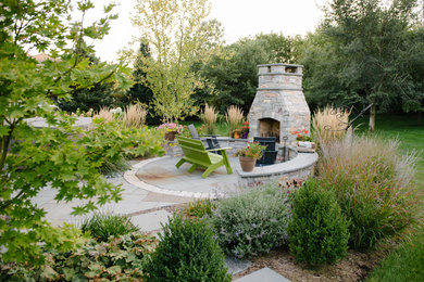 Patio - mid-sized traditional backyard stone patio idea in Other with a fire pit and no cover