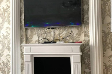 ノボシビルスクにあるラグジュアリーな広いトラディショナルスタイルのおしゃれなLDK (ベージュの壁、無垢フローリング、標準型暖炉、金属の暖炉まわり、壁掛け型テレビ、茶色い床) の写真