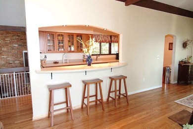 Enclosed kitchen - large traditional galley light wood floor and beige floor enclosed kitchen idea in DC Metro with an undermount sink, raised-panel cabinets, light wood cabinets, solid surface countertops, white appliances and no island