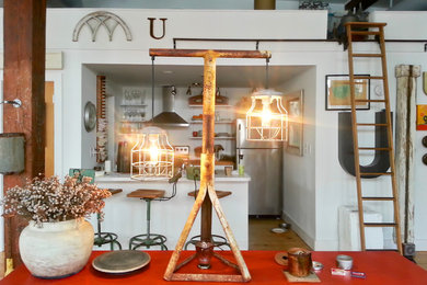 Eat-in kitchen - small eclectic galley light wood floor eat-in kitchen idea in Richmond with a single-bowl sink, flat-panel cabinets, white cabinets, laminate countertops, stainless steel appliances and an island
