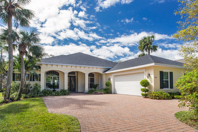 Inspiration for a large coastal yellow one-story exterior home remodel in Orlando