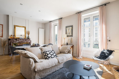 Cette image montre une salle à manger traditionnelle de taille moyenne avec un mur beige, parquet clair, un manteau de cheminée en pierre et boiseries.