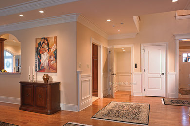 Example of a mid-sized classic medium tone wood floor hallway design in Houston with beige walls
