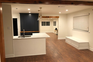 Mid-sized transitional u-shaped medium tone wood floor, brown floor and exposed beam open concept kitchen photo in New Orleans with a peninsula, shaker cabinets, white cabinets, quartzite countertops, white backsplash, white countertops, an undermount sink, ceramic backsplash and stainless steel appliances