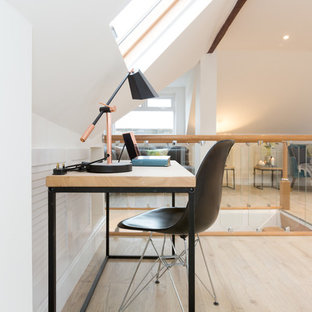 Photo of a contemporary home office and library in London with white walls, a freestanding desk, light hardwood flooring and beige floors.