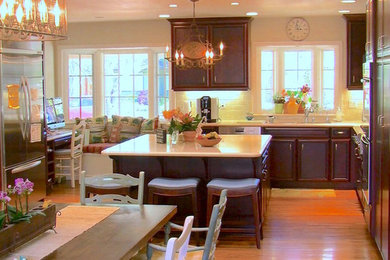 Eat-in kitchen - mid-sized transitional l-shaped medium tone wood floor eat-in kitchen idea in San Francisco with dark wood cabinets, white backsplash, ceramic backsplash, stainless steel appliances and an island