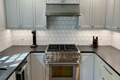 Example of a mid-sized transitional u-shaped eat-in kitchen design in Seattle with shaker cabinets, gray cabinets, quartz countertops and black countertops