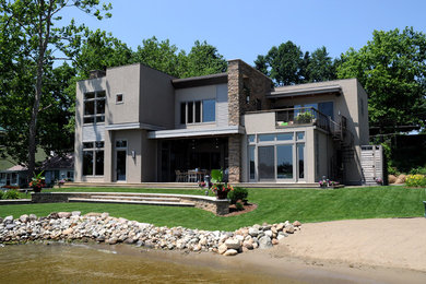 Large trendy gray two-story mixed siding flat roof photo in Other