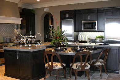Eat-in kitchen - huge mediterranean l-shaped travertine floor eat-in kitchen idea in Orange County with an undermount sink, shaker cabinets, dark wood cabinets, quartz countertops, multicolored backsplash, porcelain backsplash, stainless steel appliances and two islands