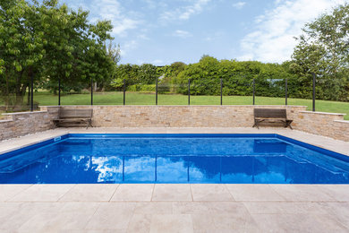 Mid-sized modern backyard rectangular lap pool in Melbourne with natural stone pavers.