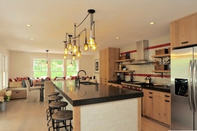 Trendy single-wall light wood floor kitchen photo in Boston with a drop-in sink, flat-panel cabinets, medium tone wood cabinets, limestone countertops, red backsplash, ceramic backsplash, stainless steel appliances and an island