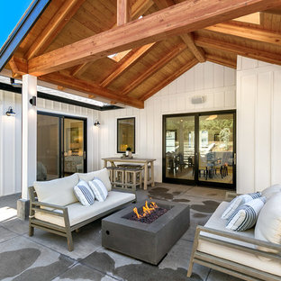 Mittelgroßer, Überdachter Landhaus Patio hinter dem Haus mit Feuerstelle und Betonplatten in Seattle