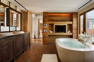 This is an example of a large industrial master bathroom in New York with a vessel sink, flat-panel cabinets, dark wood cabinets, a freestanding tub, beige walls, medium hardwood floors and brown floor.