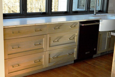 Inspiration for a mid-sized craftsman u-shaped medium tone wood floor and brown floor eat-in kitchen remodel in Other with a farmhouse sink, shaker cabinets, distressed cabinets, granite countertops, white backsplash, subway tile backsplash, black appliances, an island and beige countertops