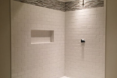Example of a transitional white tile and subway tile porcelain tile corner shower design in Milwaukee with gray walls