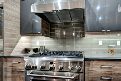 Large trendy open concept kitchen photo in Edmonton with flat-panel cabinets, gray cabinets, quartz countertops, gray backsplash, ceramic backsplash, stainless steel appliances and an island