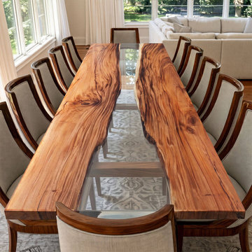 Two live‑edge walnut slabs are joined by a clear epoxy river – creating a dining