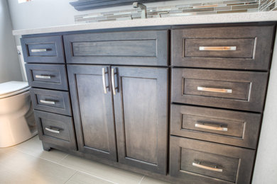 Inspiration for a transitional master gray tile ceramic tile bathroom remodel in Other with recessed-panel cabinets, dark wood cabinets, gray walls, an undermount sink and quartz countertops