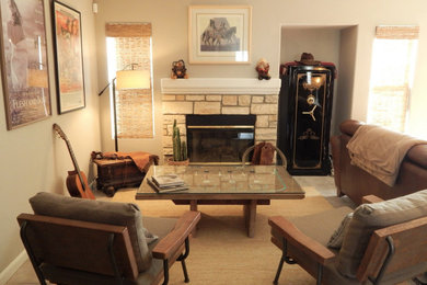Inspiration for a mid-sized southwestern enclosed porcelain tile and beige floor family room remodel in Los Angeles with gray walls, a standard fireplace, a stone fireplace and a wall-mounted tv