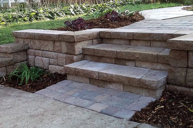 Photo of a mid-sized traditional drought-tolerant and partial sun backyard concrete paver retaining wall landscape in Minneapolis.