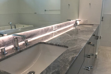 Example of a trendy master bathroom design in Houston with an undermount sink and marble countertops