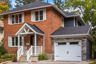 Photo of a transitional two-storey blue exterior in Toronto with vinyl siding and a gable roof.