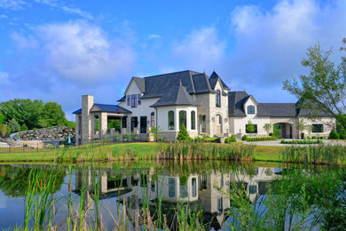 Example of a huge french country beige three-story mixed siding house exterior design in Indianapolis with a mixed material roof and a gray roof