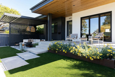 Example of a danish front yard concrete paver patio design in San Diego with a fire pit and a pergola