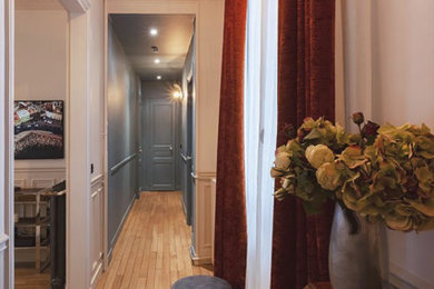Cette image montre une entrée design avec un couloir, un mur bleu et parquet clair.