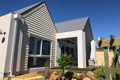 This is an example of a beach style exterior in Perth with a gable roof and a metal roof.