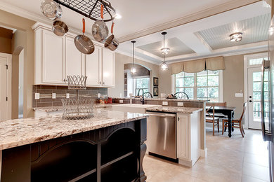 Eat-in kitchen - transitional l-shaped eat-in kitchen idea in Other with a farmhouse sink, flat-panel cabinets, white cabinets, granite countertops, gray backsplash, ceramic backsplash, stainless steel appliances and an island