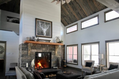 Example of a large open concept gray floor living room design in Ottawa with white walls, a wood stove and a stone fireplace